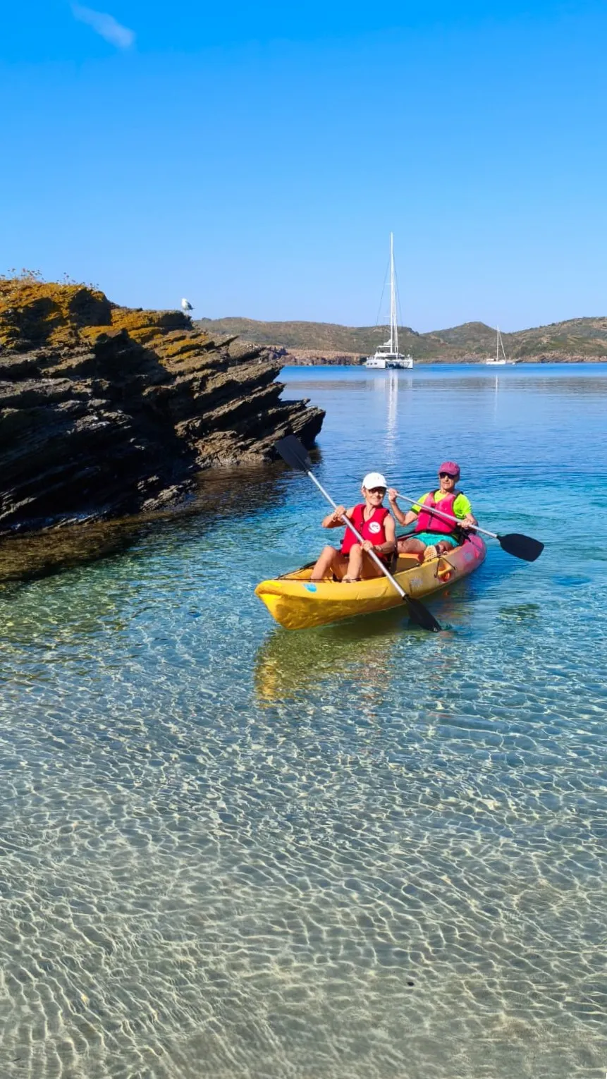 Deux personnes dans un kayak double autovideur près d’une côte rocheuse